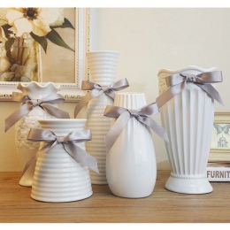 Eleganckie dekoracyjne białe ceramiczne wazony w nowoczesnym kształcie z ozdobną satynową wstążką na kwiaty wysokie wazy